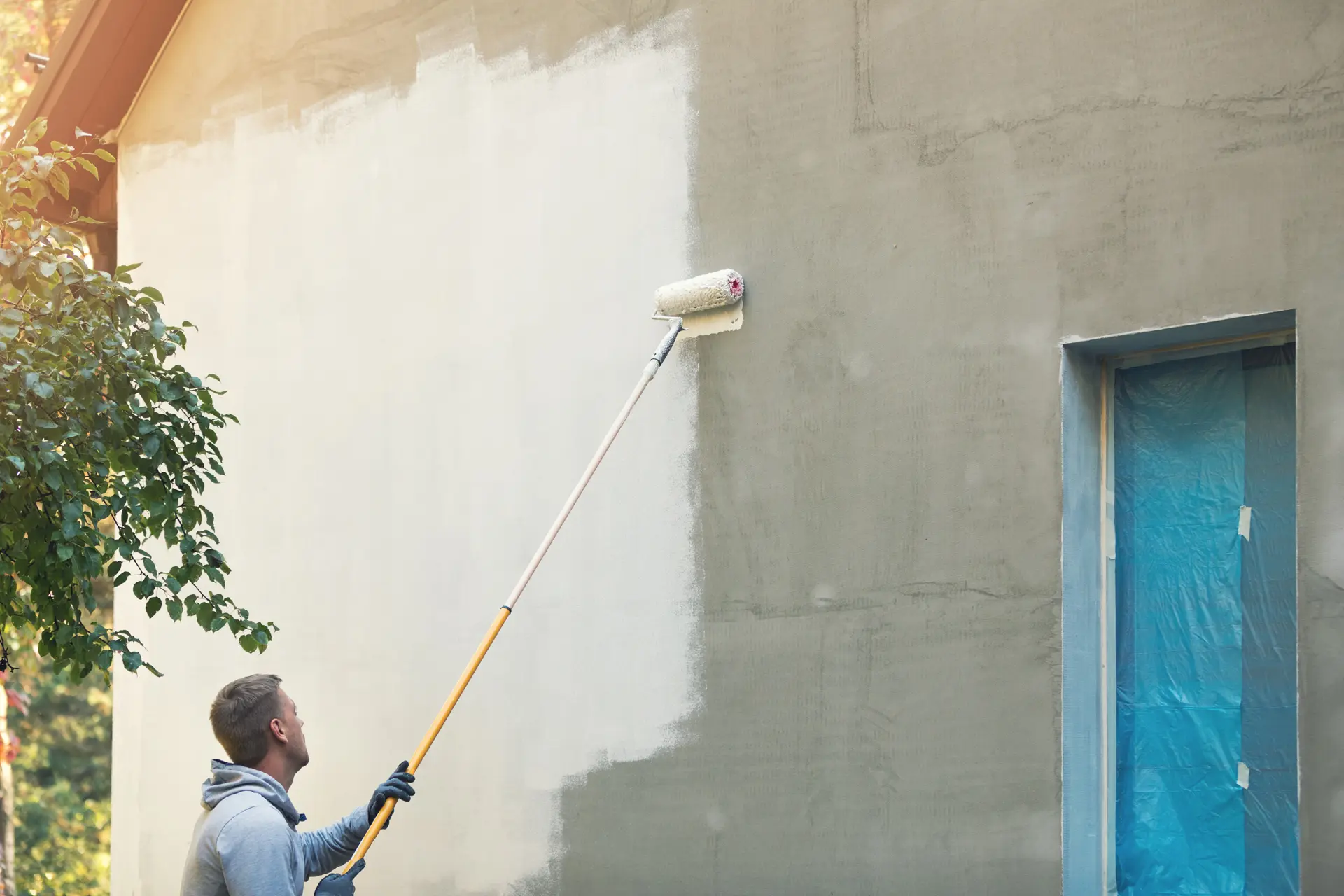 Pintor trabajando en una fachada en Torrente